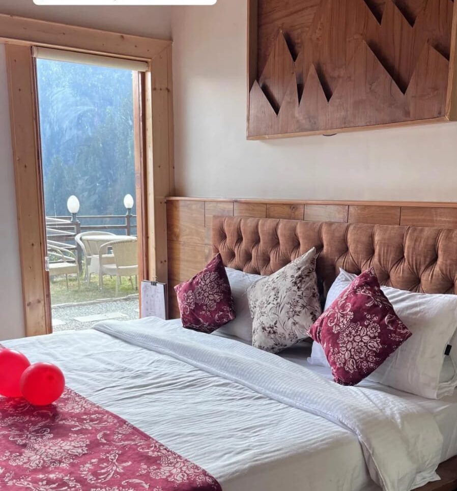 Suite with sliding doors open onto the courtyard, chairs, and the valley beyond